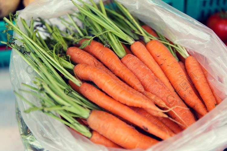 销售,收获,食品,蔬菜和农业的概念— —在街边市场上的塑料袋胡萝卜